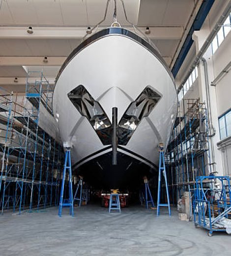 Front view of a large luxury motor yacht in a ship building facility